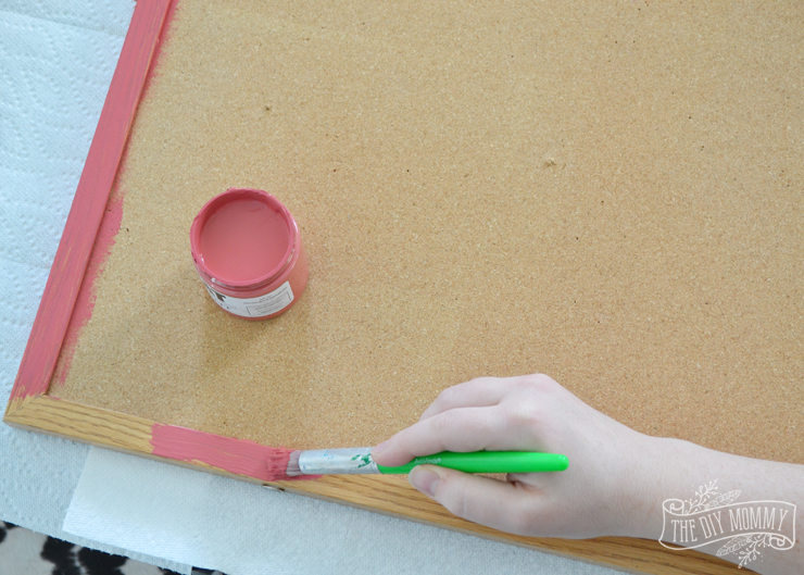 How to make a covered bulletin board with paint, fabric and brass upholstery tacks.
